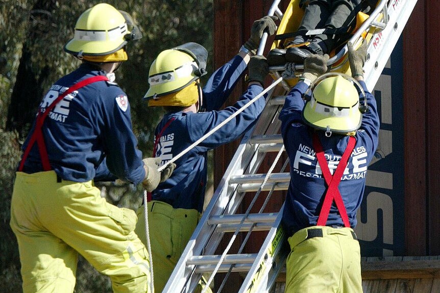 NSW firefighters lower an injured office worker down a ladder during a hypothetical emergency.