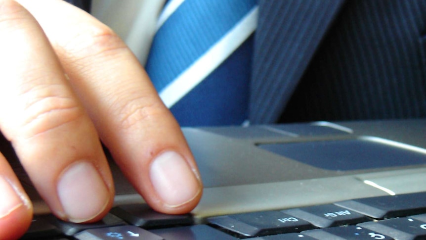 A businessman works at a laptop.