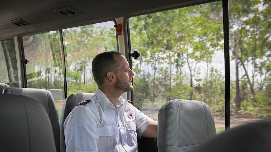 Captain Kris Halliday rides as a passenger on a bus, looking out the window.
