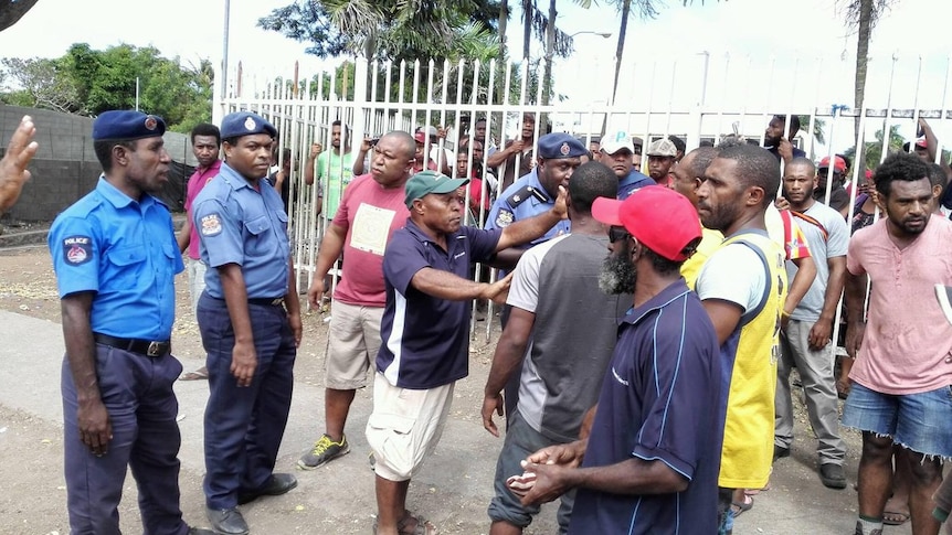PNG police facing angry men.