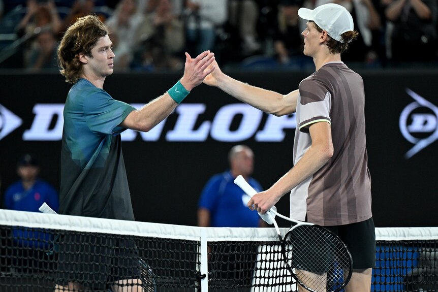 Andrey Rublev and Jannik Sinner shake hands at the net in the 2024 Australian Open match.