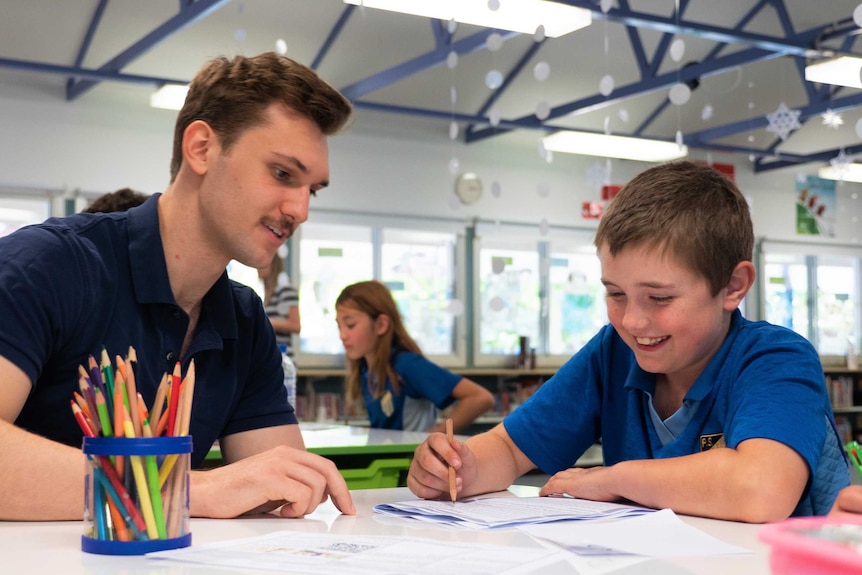 Caleb Bean sits with his tutor