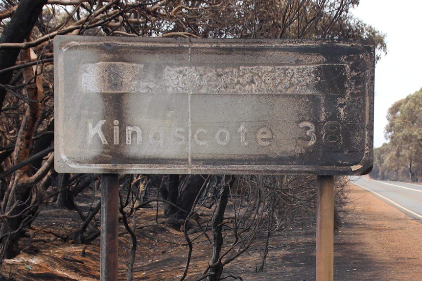 A burnt Kingscote sign on a highway