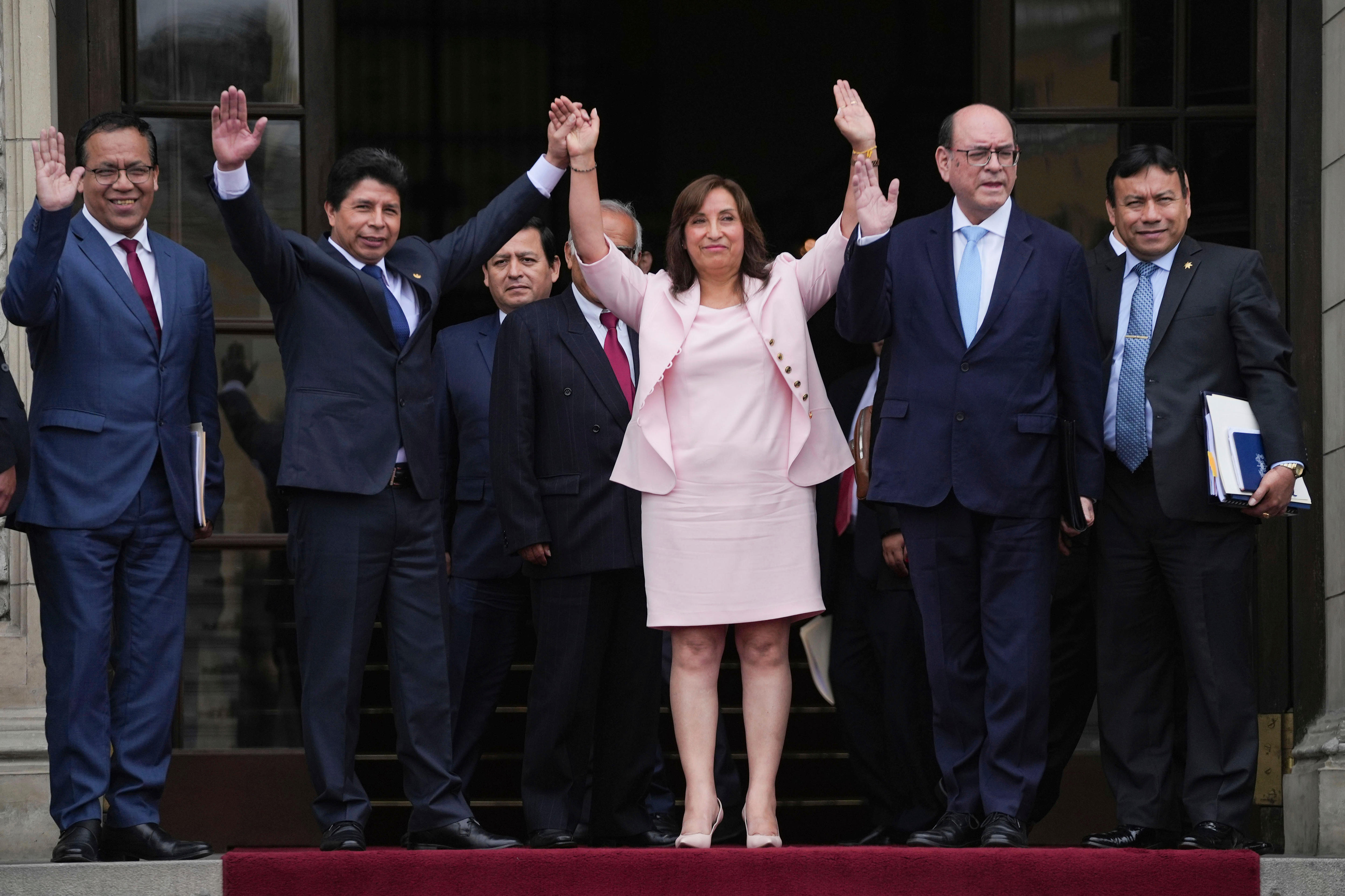 Group picture of men and a women waving at their supporters 