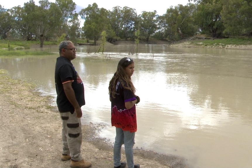 Owen and Amelia Whyman stand on th banks for the Darling River in Wilcannia