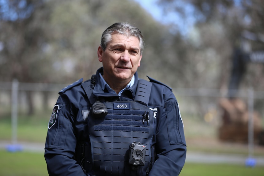 Police officer wearing a dark blue uniform. 
