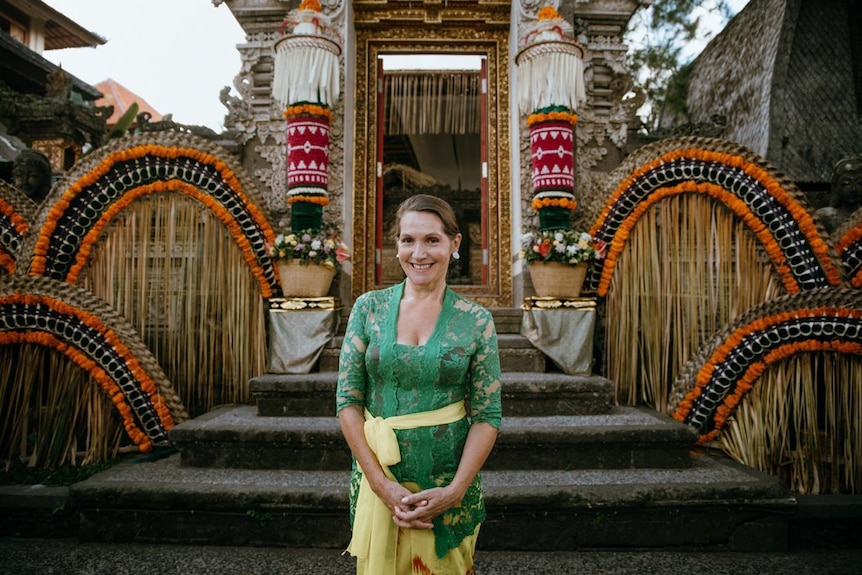 A woman standing outside a traditional building in Bali