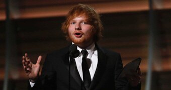 Ed Sheeran happily accepts award on stage.