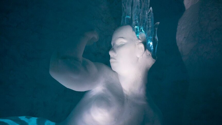 An ice sculpture of a fit mermaid