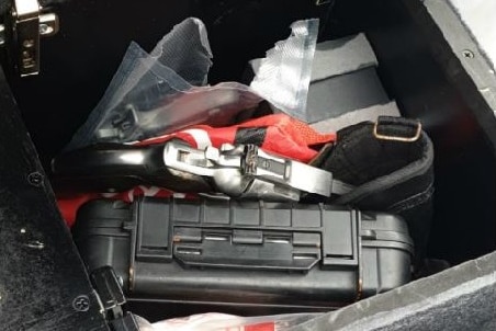 A centre console compartment of a car containing guns