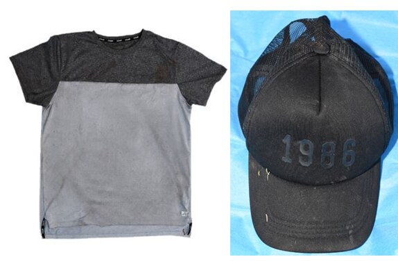 A grey shirt with black upper section is on the left. A black cap saying 1986 is on the right.
