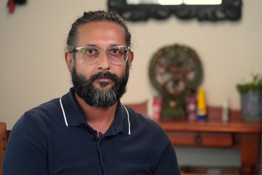 Binod Budhathoki has a beard and wears glasses.