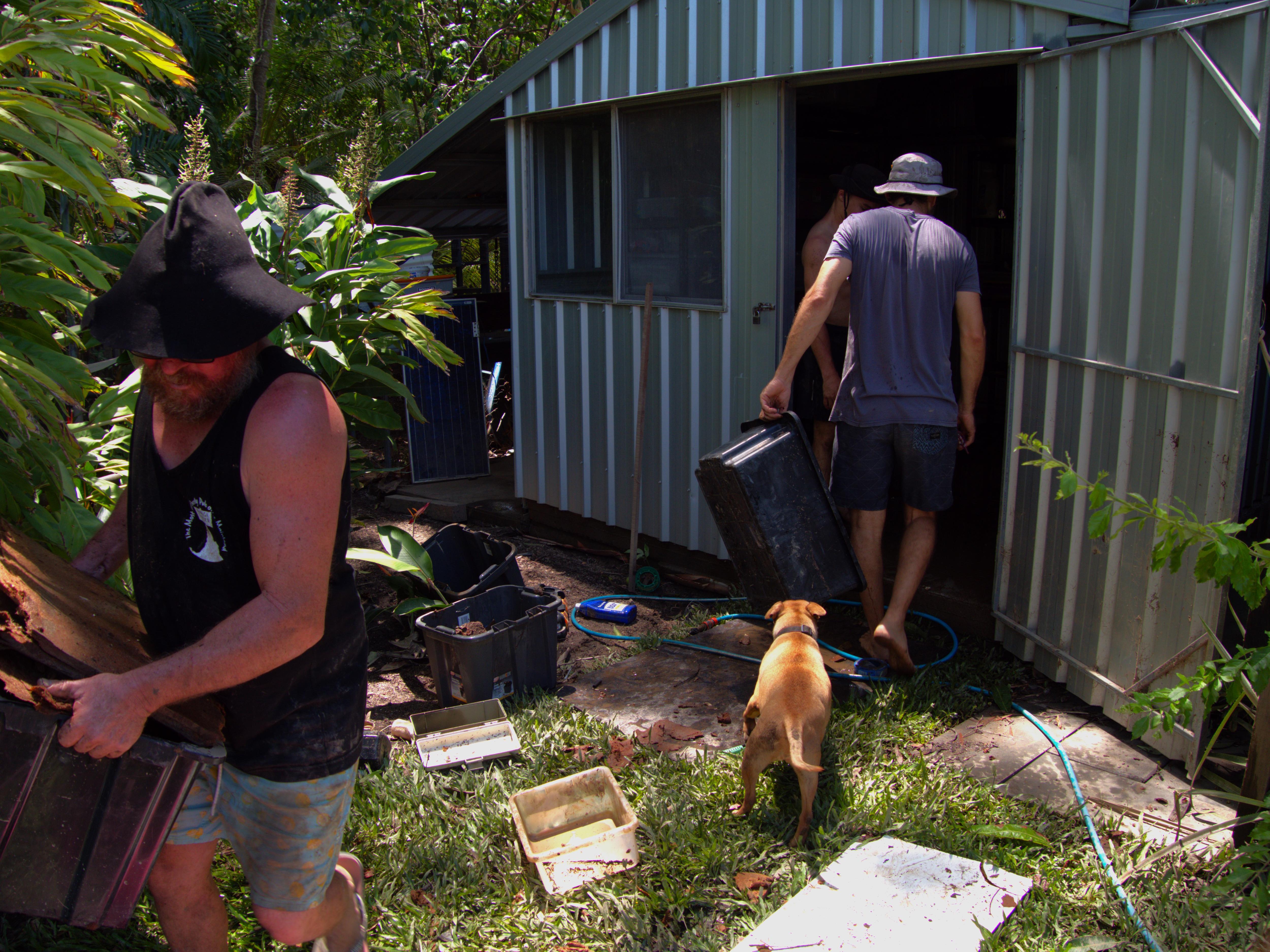two men clearing a shed