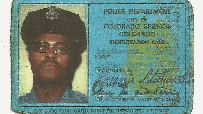 A blue ID card showing Ron Stallworth as a member of the Colorado Springs Police Department.