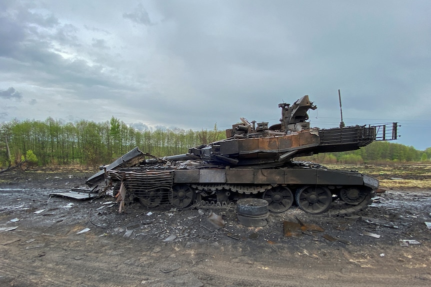 A destroyed Russian tank on a country road.