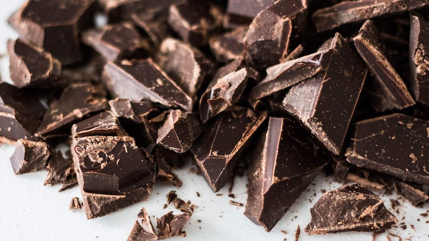 Crushed up chocolate sitting on a white background.