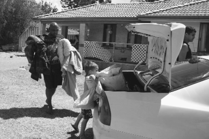 Man and boy pack blankets into car.