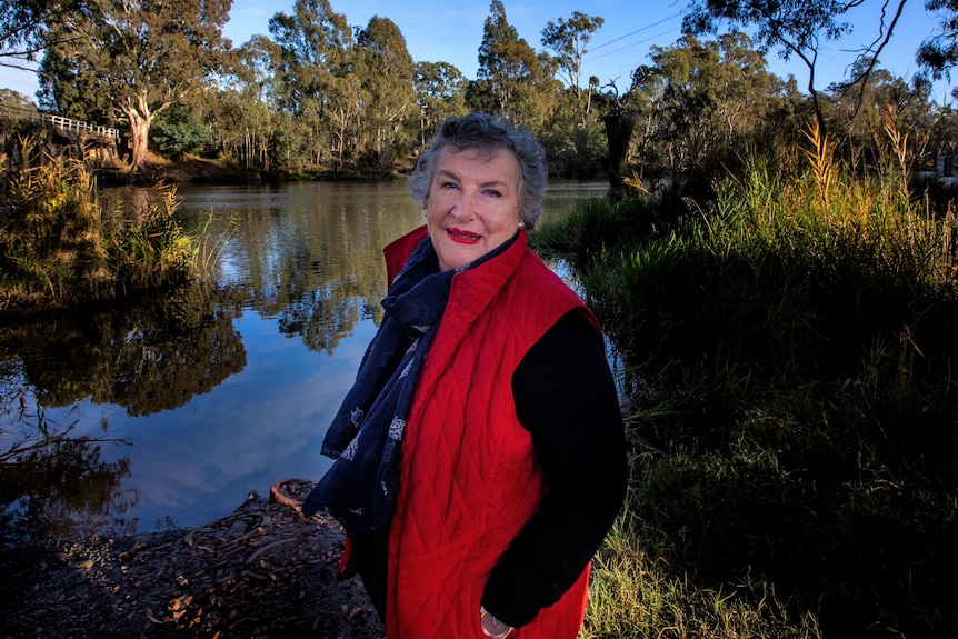 A woman standing in front of a creek/river 