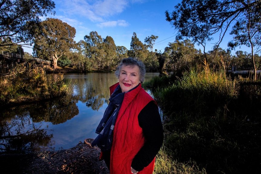 A woman standing in front of a creek/river 