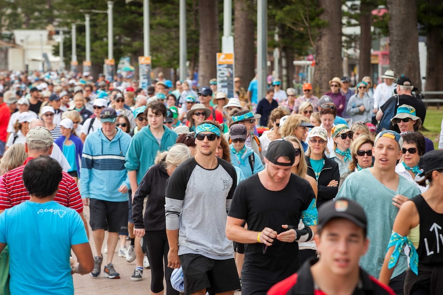 A large group of people taking part in a group walk.