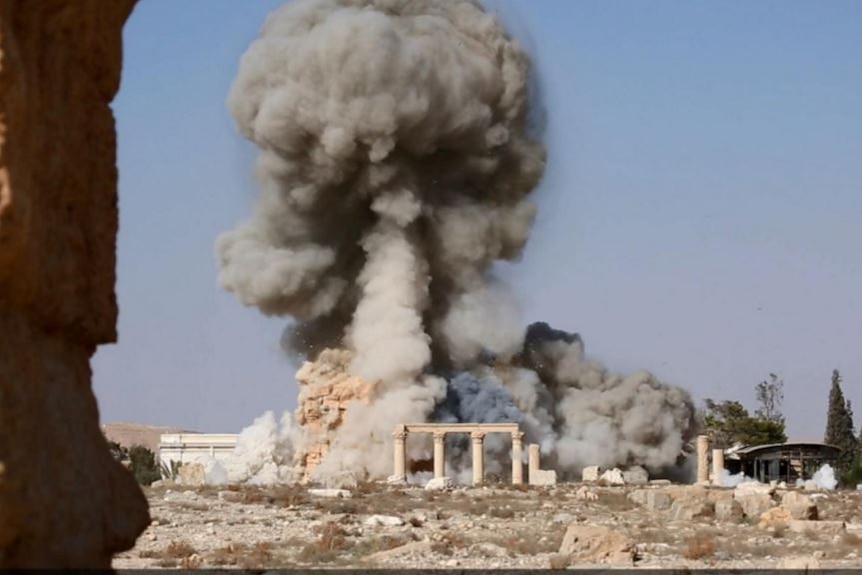 Smoke rises up over roman ruins in Palmyra.