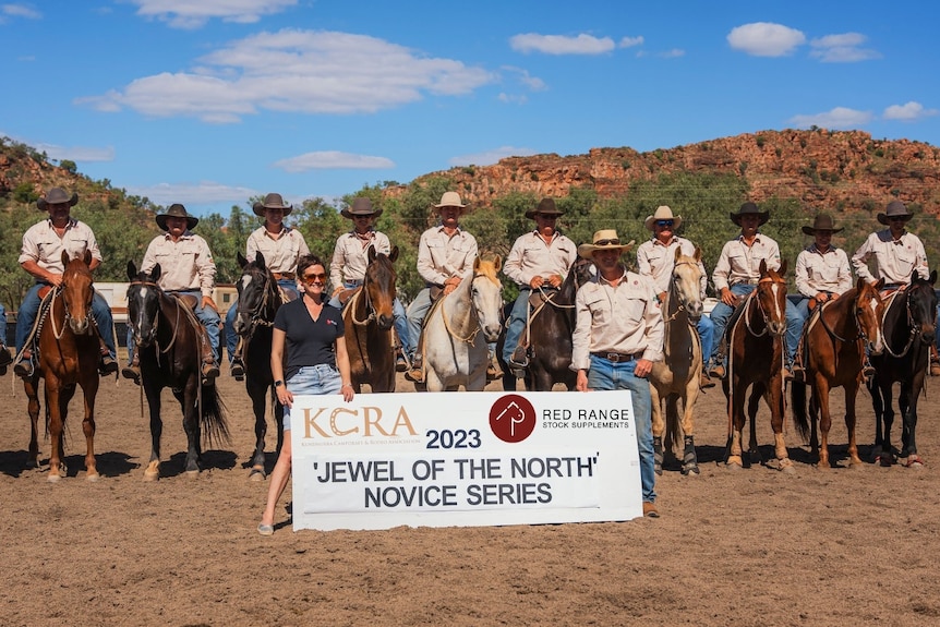 A group of people in front of a sign.