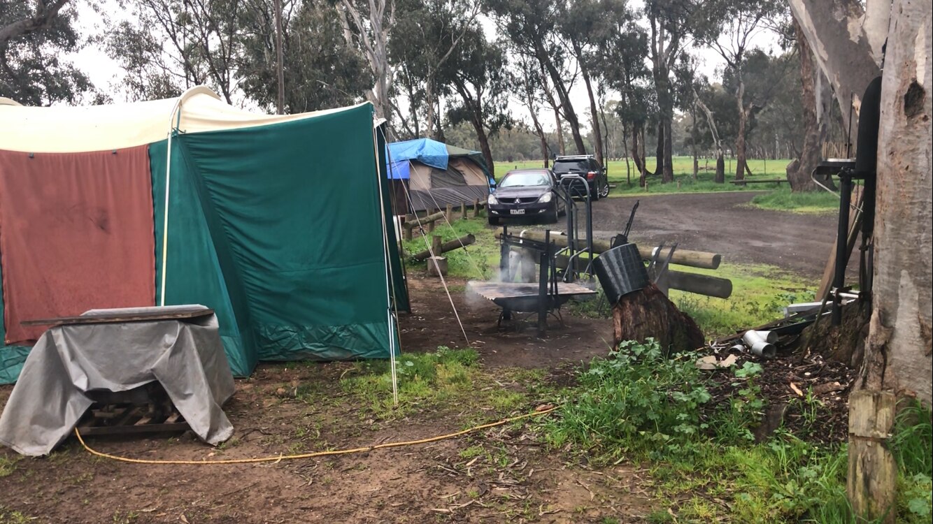 a tent sits in the middle of muddy picnic ground