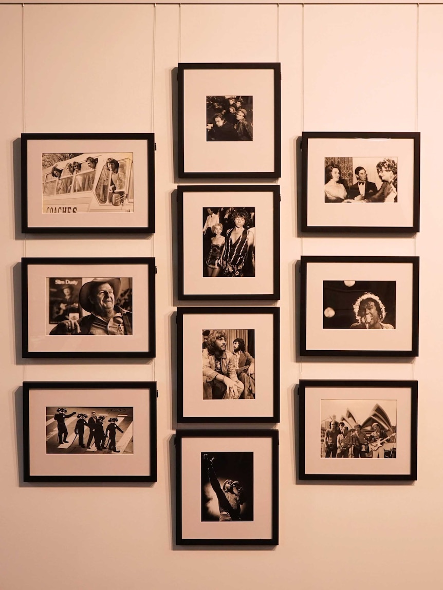 Framed photographs hang on a white wall