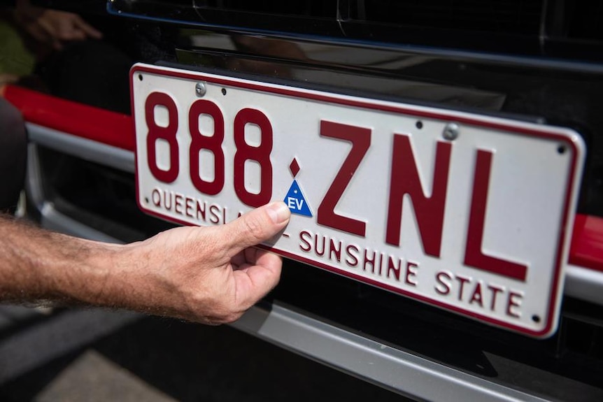 A car number plate with a small blue "EV" label.