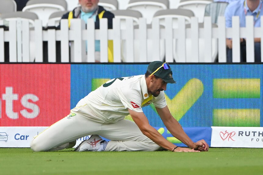 Australia fielder Mitchell Starc touches the ball to the ground as he takes a catch during a Test.