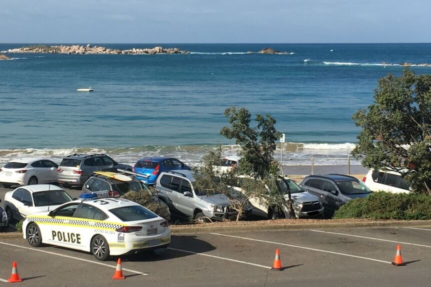 A carpark full of vehicles next to the ocean