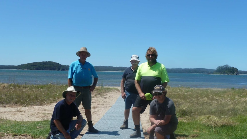 Volunteers pose with the completed boardwalk