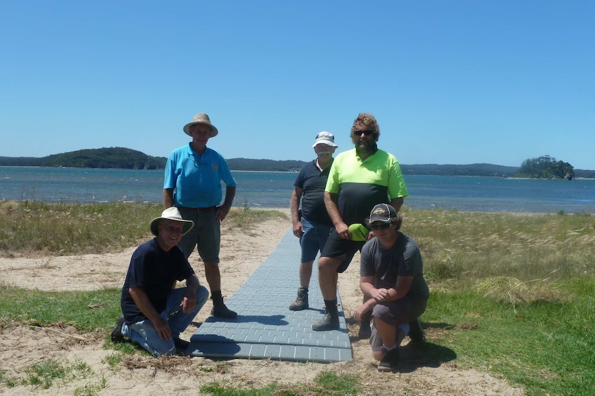 Volunteers pose with the completed boardwalk