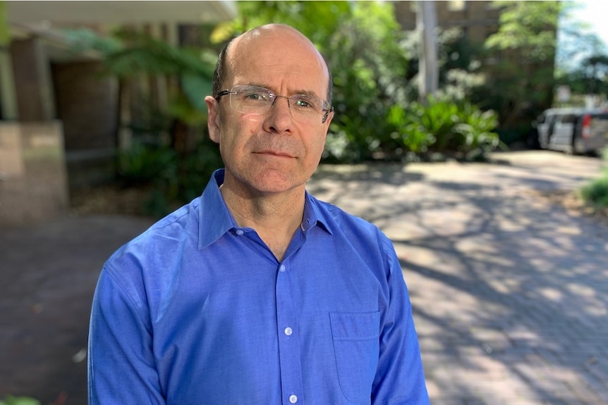 A portrait of a man in a courtyard.