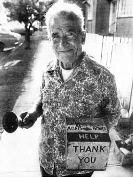 пожилой мужчина на улице держит коробку для сбора средств для домов престарелых