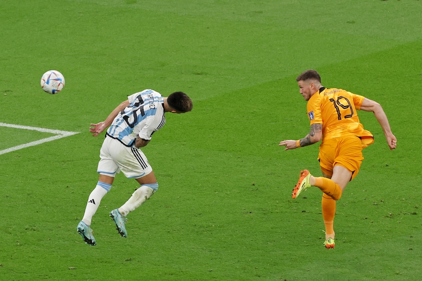 A player contorts his body to head a ball past his opponent.