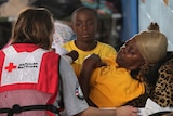 A Red Cross worker speaks with a flood evacuee at a shelter set up in a high school gym at Kentwood, Louisiana.