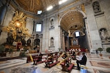 Pope Francis celebrates Palm Sunday Mass behind closed doors in a mostly empty St. Peter's Basilica.