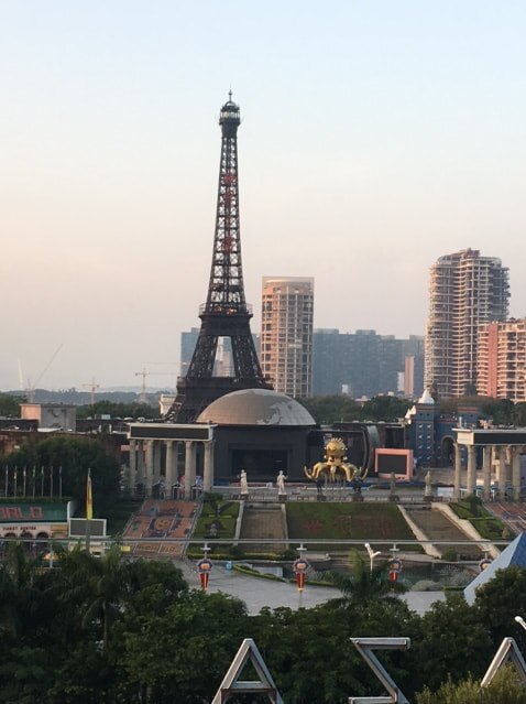 A replica Eiffel Tower stands next to apartment towers.