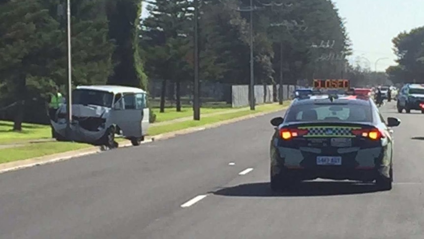 A van crashed into a pole with a police car blocking traffic
