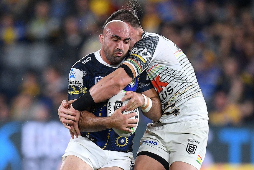 Tim Mannah is tackled around his upper body by Tim Grant as he holds the ball.