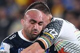 Tim Mannah is tackled around his upper body by Tim Grant as he holds the ball.