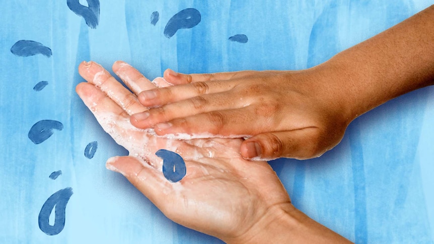A pair of soapy hands rinse under water.
