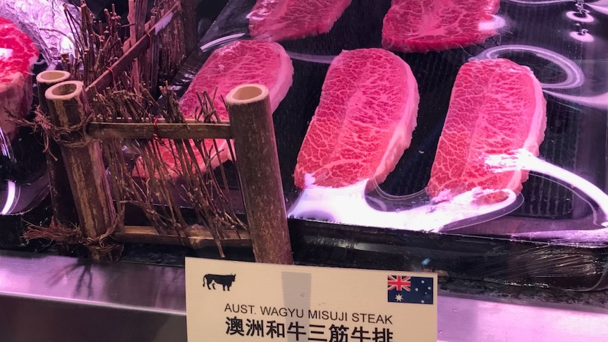 Beef steaks in a butcher with above a sign with both Chinese and English writing
