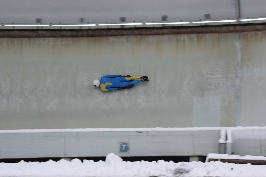 Skeleton racer Elliot Brown racing down an icy track in Europe.