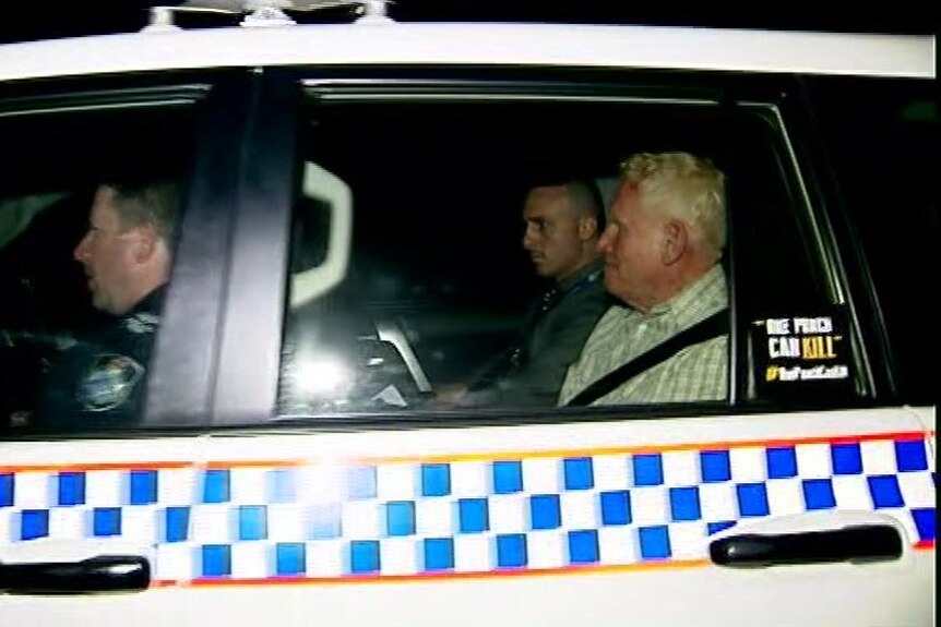 Richard Dudley Kelsey in the back seat of a police car. 