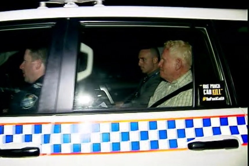 Richard Dudley Kelsey in the back seat of a police car. 