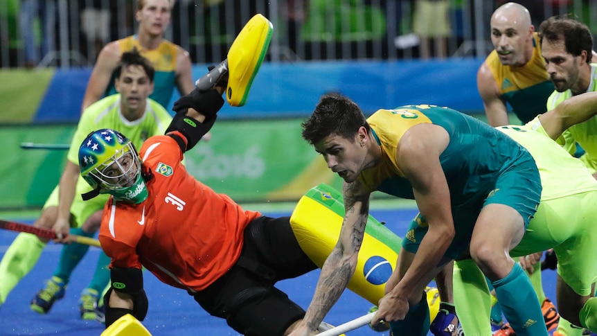 Australian hockey player Blake Govers fights for the ball against Brazil in Rio