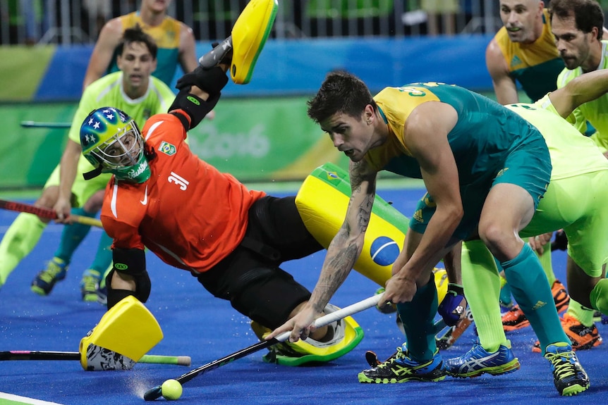 Australian hockey player Blake Govers fights for the ball against Brazil in Rio