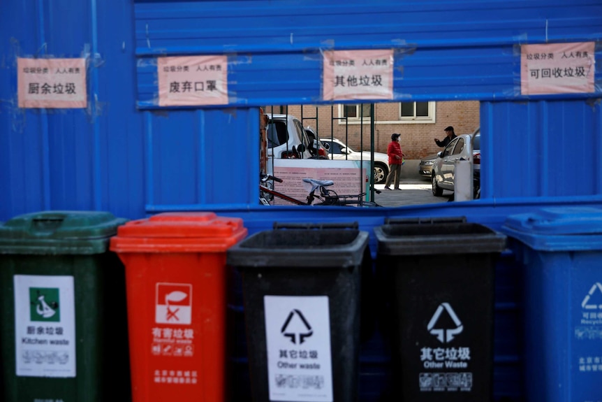 A row of bins outside a residential apartment. One is for masks and hazardous waste.